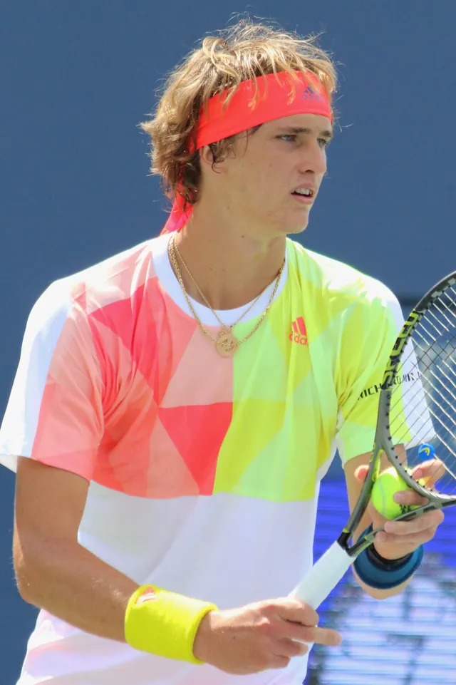 Alexander Zverev mit rotem Stirnband und buntem Shirt hält Ball und Schläger, US Open 2016